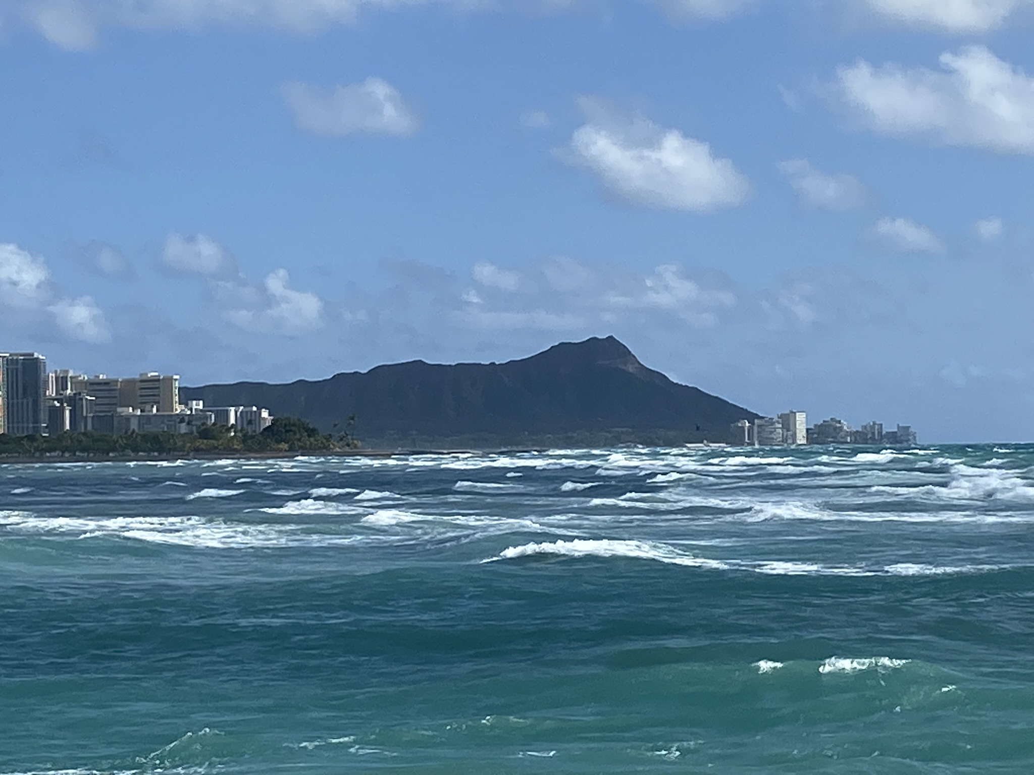 Diamond Head rising above the South Shore of Oʻahu, seen across the water from Point Panic.